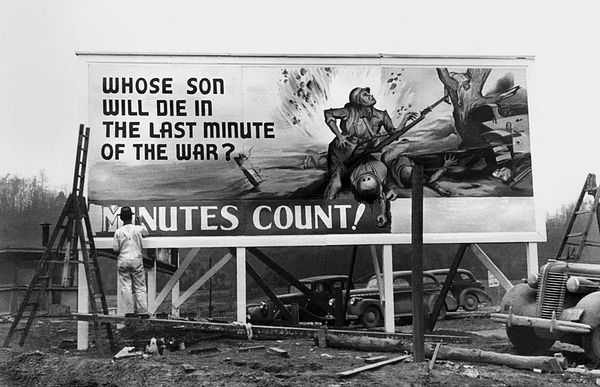 13. 一幅告示牌，橡树岭，摄于二战期间，1944 年 1 月 21 日摄。标牌大意： “战争的最后一分钟又将让谁的儿子死去？每一分钟都是至关重要的。”（Ed Westcott/DOE）